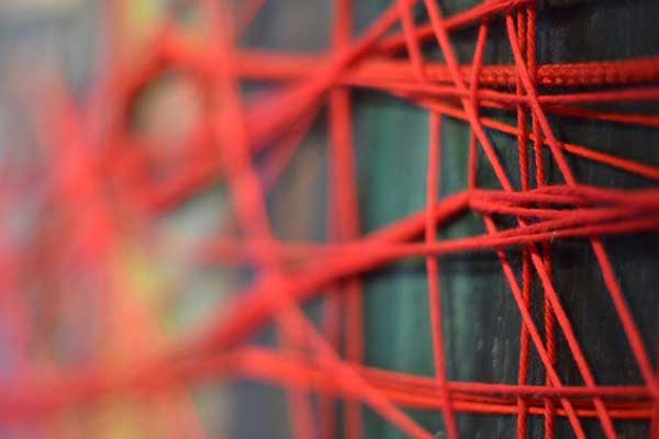 Extreme close-up of red tangled cord on Wounded painting