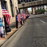 Attendees lone the street with flags to welcome the arrival of the Hometown Hero exhibit