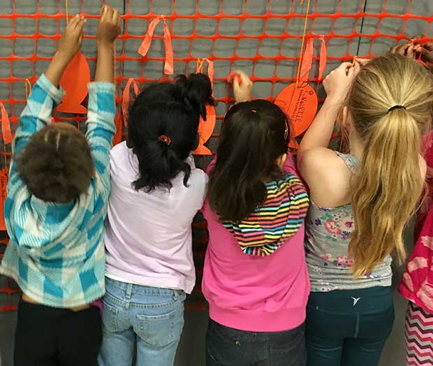Students at Virginia school tying paper koy fish with kindness promises on Color Me Orange—Color Me Kind
