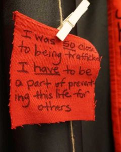 Close-up detail of red denim message on Red Jeans Redemption