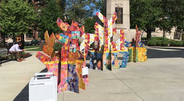 Decorated broken tree sculptures for Pamela Alderman's ArtPrize 2021 Yellow Ribbon installation